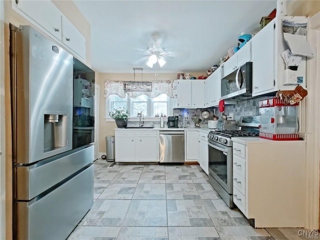 801 W Thomas St, Rome-Inside, NY 13440 - kitchen featuring stainless steel appliances, light countertops, white cabinets, ceiling fan, and tasteful backsplash
