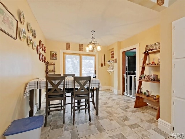 801 W Thomas St, Rome-Inside, NY 13440 - dining area with a chandelier, baseboards, and light stone finish flooring