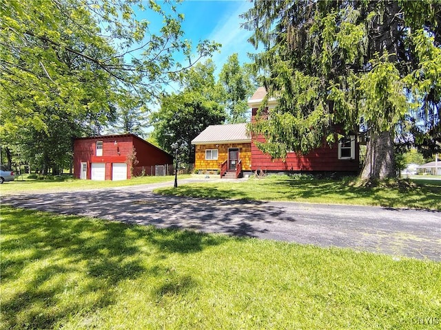 801 W Thomas St, Rome-Inside, NY 13440 - view of front of house with driveway, an outbuilding, a garage, a front lawn, and metal roof