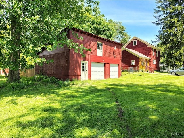 801 W Thomas St, Rome-Inside, NY 13440 - back of house with a lawn, an attached garage, and driveway