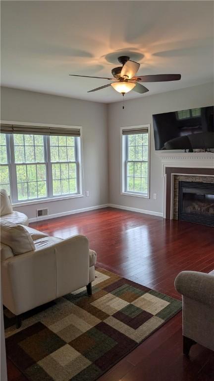 12 Probst Rd, Mendon, NY 14534 - living area featuring plenty of natural light, wood finished floors, a fireplace, and ceiling fan