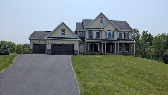12 Probst Rd, Mendon, NY 14534 - view of front facade with driveway, stone siding, a front lawn, an attached garage, and covered porch