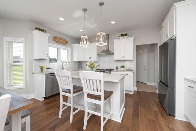 8 Giovanni Ln, Parma, NY 14468 - kitchen featuring stainless steel appliances, wall chimney range hood, light countertops, decorative backsplash, and recessed lighting