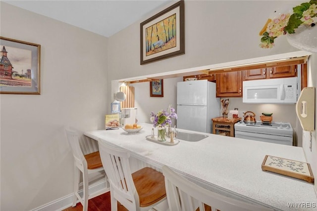 270 Buffalo Rd Unit 72, Aurora, NY 14052 - kitchen featuring white appliances, brown cabinetry, light countertops, and wood finished floors