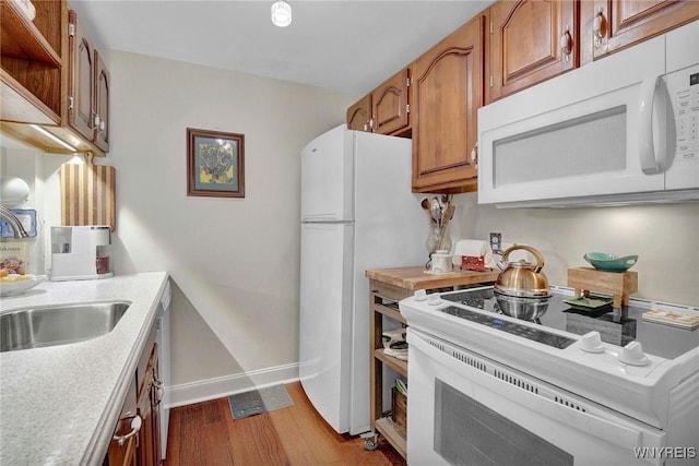 270 Buffalo Rd Unit 72, Aurora, NY 14052 - kitchen featuring white appliances, light countertops, baseboards, wood finished floors, and brown cabinetry
