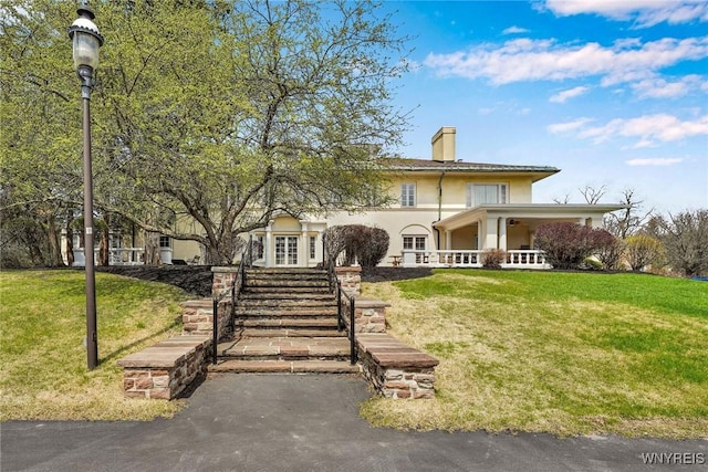 270 Buffalo Rd Unit 72, Aurora, NY 14052 - view of front of house with a front yard, a chimney, stucco siding, and a ceiling fan