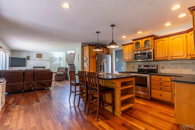 3 Foxwood Dr, Lysander, NY 13027 - kitchen with stainless steel appliances, dark countertops, open floor plan, brown cabinetry, and recessed lighting