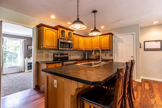 3 Foxwood Dr, Lysander, NY 13027 - kitchen with stainless steel appliances, a sink, dark countertops, brown cabinets, and recessed lighting