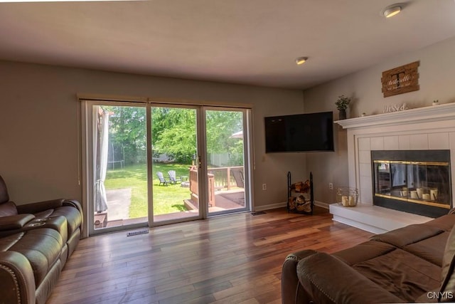 3 Foxwood Dr, Lysander, NY 13027 - living room featuring wood-type flooring, baseboards, and a tiled fireplace