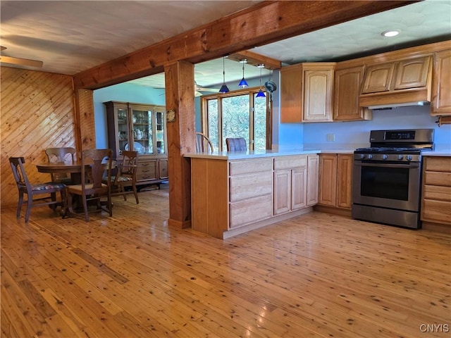 4300 Mutton Hill Rd, Fenner, NY 13035 - kitchen featuring stainless steel range with gas stovetop, wood walls, light countertops, ceiling fan, and light wood-style floors