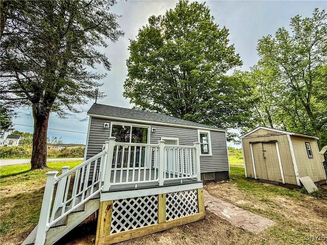 58 Van Ness Rd S, Van Buren, NY 13027 - rear view of property featuring a shed, a deck, a yard, and roof with shingles
