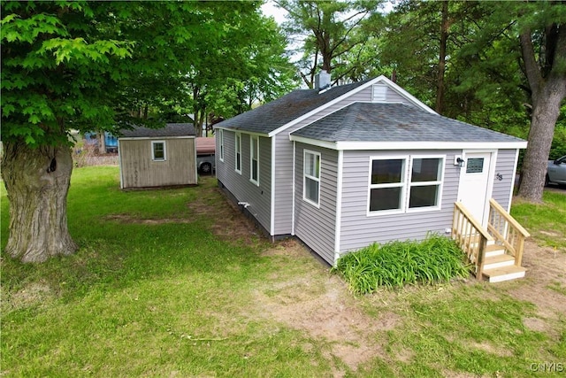 58 Van Ness Rd S, Van Buren, NY 13027 - view of home's exterior featuring entry steps, roof with shingles, a lawn, a storage shed, and a chimney