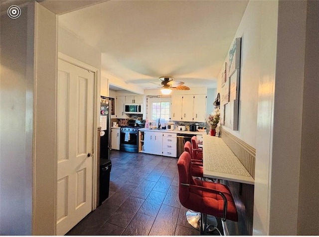 61 Tamarack, Irondequoit, NY 14622 - kitchen with appliances with stainless steel finishes, white cabinetry, ceiling fan, light countertops, and a sink