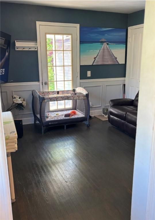 61 Tamarack, Irondequoit, NY 14622 - sitting room with wood finished floors, wainscoting, a wall mounted AC, and a decorative wall