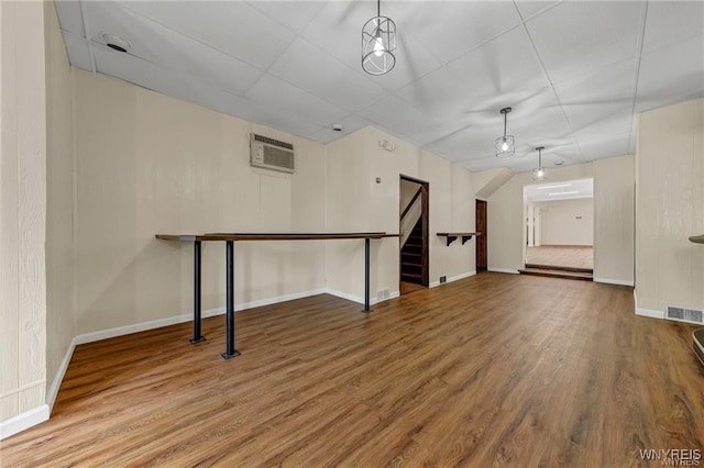 3045 Niagara St, Niagara Falls, NY 14303 - unfurnished living room featuring stairway, wood finished floors, baseboards, and a wall mounted air conditioner