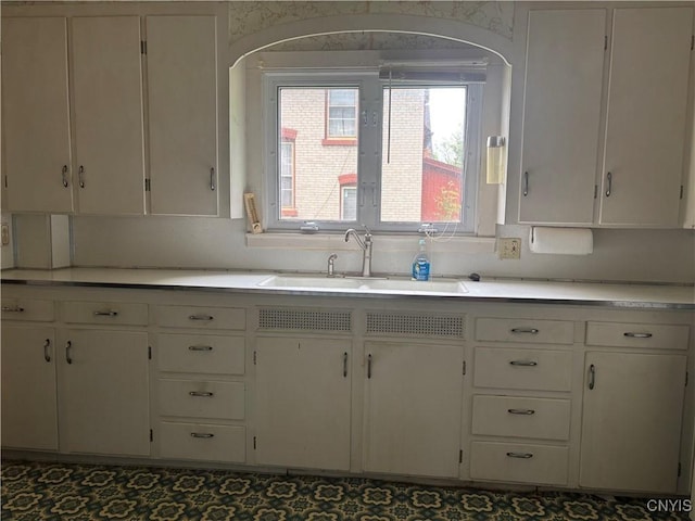 10 Otter Creek Pl, Cortland, NY 13045 - kitchen featuring a sink, light countertops, arched walkways, and white cabinets