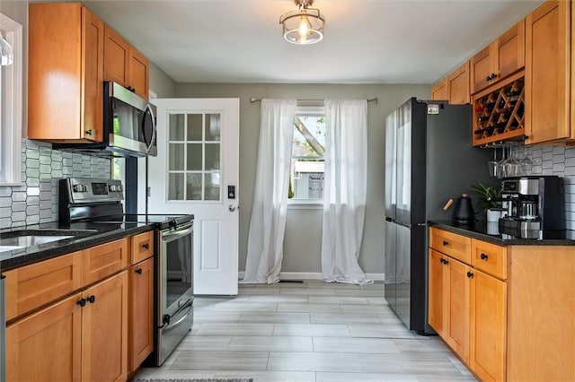 669 Webster Rd, Webster, NY 14580 - kitchen featuring appliances with stainless steel finishes, backsplash, baseboards, and dark stone counters