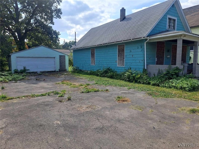 1137 N Ave, Niagara Falls, NY 14305 - view of home's exterior featuring a chimney, a detached garage, an outdoor structure, and a shingled roof