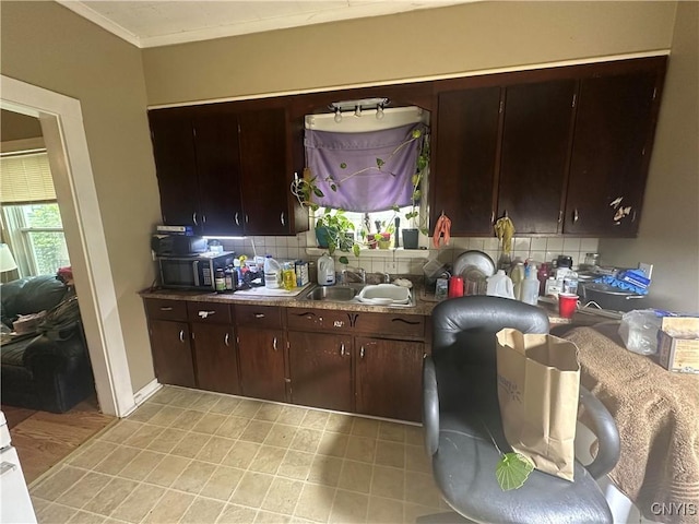 319 Shuart Ave, Syracuse, NY 13203 - kitchen featuring a sink, tasteful backsplash, dark brown cabinets, and ornamental molding