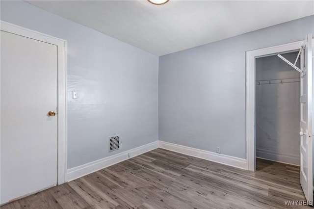 46 Wilkes Ave, Buffalo, NY 14215 - unfurnished bedroom featuring wood finished floors, a closet, baseboards, and a spacious closet