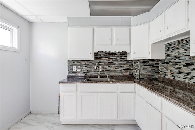 46 Wilkes Ave, Buffalo, NY 14215 - kitchen featuring a sink, light marble finish flooring, white cabinets, decorative backsplash, and dark stone counters