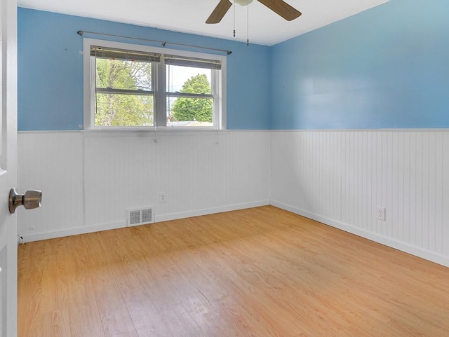 13 W Crest Dr, Gates, NY 14606 - empty room featuring a wainscoted wall, wood finished floors, and a ceiling fan