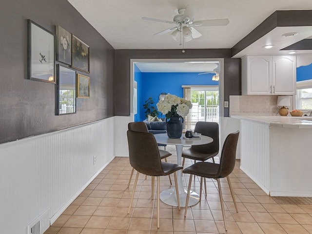 13 W Crest Dr, Gates, NY 14606 - dining area with ceiling fan, light tile patterned floors, and wainscoting