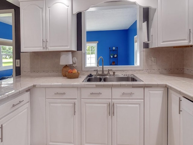 13 W Crest Dr, Gates, NY 14606 - kitchen with a sink, white cabinetry, tasteful backsplash, and light countertops