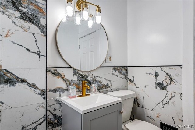57 Davidson Ave, Buffalo, NY 14215 - half bathroom with tile walls, vanity, toilet, and a chandelier