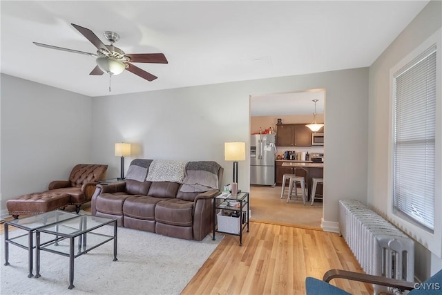 184 Liberty St, Oswego-City, NY 13126 - living room featuring radiator heating unit, light wood-type flooring, and ceiling fan