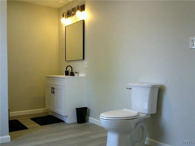 8457 S Main St, Le Ray, NY 13637 - bathroom with vanity, wood finished floors, toilet, and baseboards