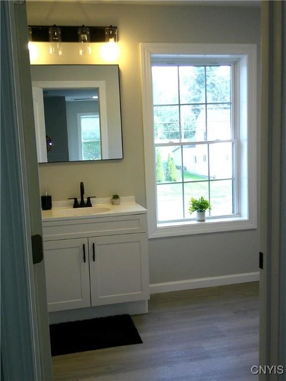 8457 S Main St, Le Ray, NY 13637 - bathroom with vanity, baseboards, wood finished floors, and healthy amount of natural light