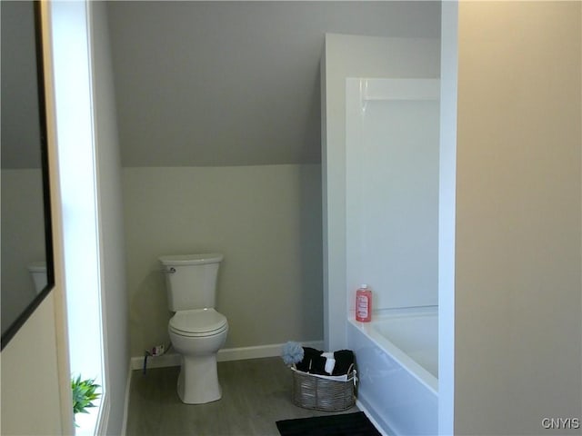 8457 S Main St, Le Ray, NY 13637 - bathroom featuring toilet, a tub to relax in, wood finished floors, and baseboards