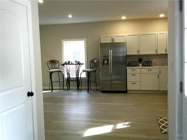 8457 S Main St, Le Ray, NY 13637 - kitchen featuring stainless steel fridge with ice dispenser, light wood-type flooring, tasteful backsplash, recessed lighting, and light countertops