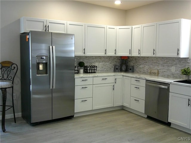 8457 S Main St, Le Ray, NY 13637 - kitchen with stainless steel appliances, backsplash, light wood-style flooring, and light stone countertops