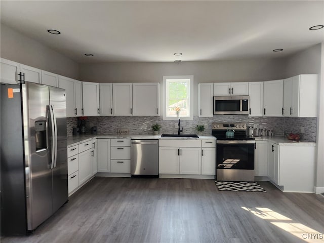 8457 S Main St, Le Ray, NY 13637 - kitchen with appliances with stainless steel finishes, wood finished floors, decorative backsplash, white cabinets, and recessed lighting