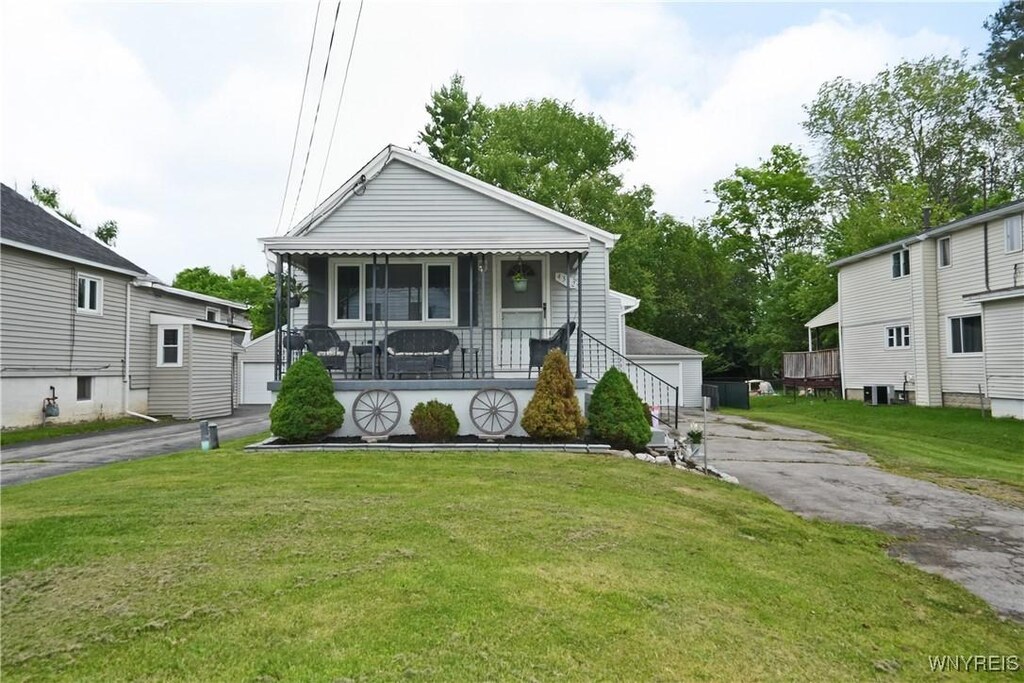 4342 Abbott Pkwy, Hamburg, NY 14219 - view of front of house with a detached garage, covered porch, a front lawn, and an outdoor structure