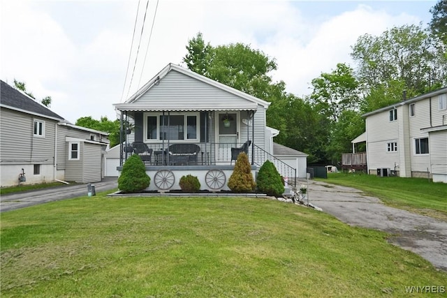 4342 Abbott Pkwy, Hamburg, NY 14219 - view of front of house with a detached garage, covered porch, a front lawn, and an outdoor structure
