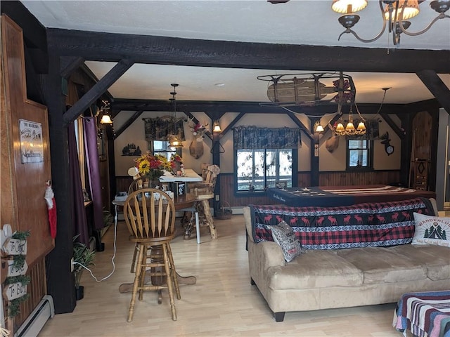 73 Derosia Rd, Lafayette, PA 16738 - living room with a chandelier, baseboard heating, a wainscoted wall, wood finished floors, and beamed ceiling