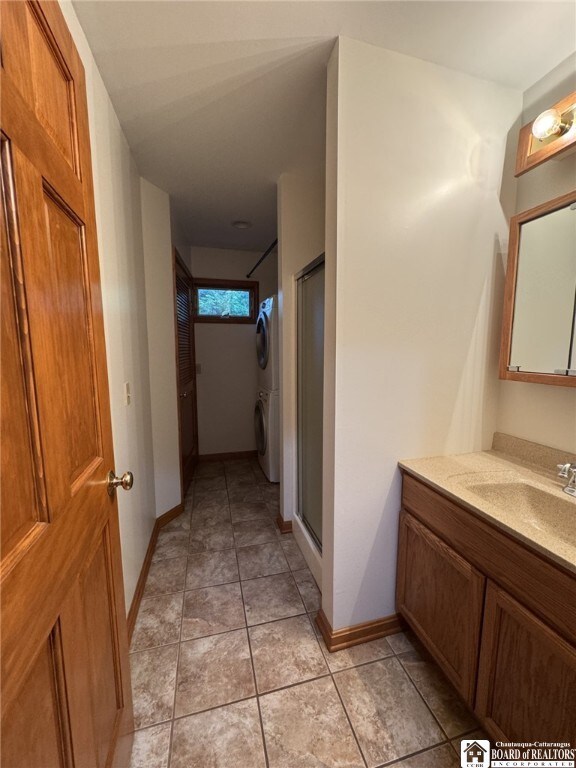 131 Goose Creek Rd, Busti, NY 14710 - bathroom with stacked washer / drying machine, vanity, and a stall shower