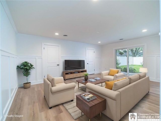 413 Chautauqua Ave, Jamestown, NY 14701 - living room featuring a decorative wall, ornamental molding, light wood-style flooring, and wainscoting