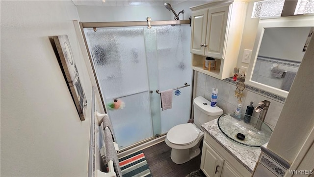 76 Sandra Dr, Cheektowaga, NY 14225 - full bathroom featuring a shower stall, vanity, toilet, tile walls, and wood finished floors