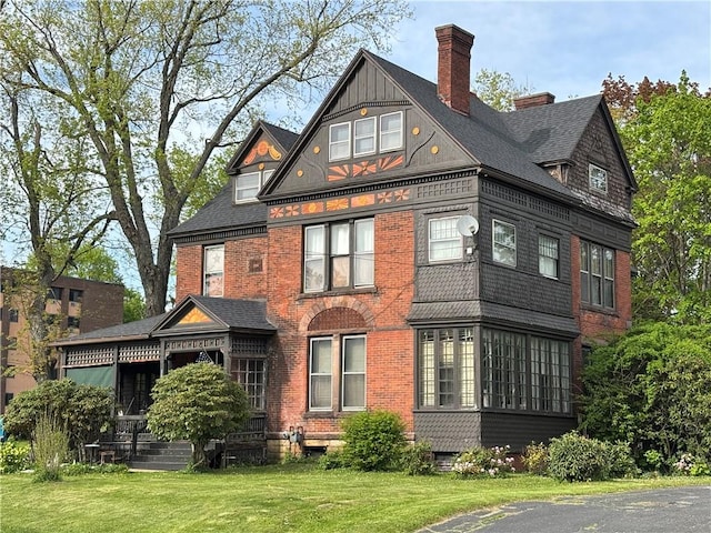 110 Edgar James St, Kane Boro, PA 16735 - back of property featuring a lawn, a chimney, brick siding, and a shingled roof