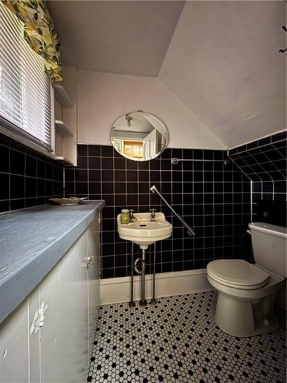 110 Edgar James St, Kane Boro, PA 16735 - bathroom with tile patterned floors, tile walls, toilet, vaulted ceiling, and a sink