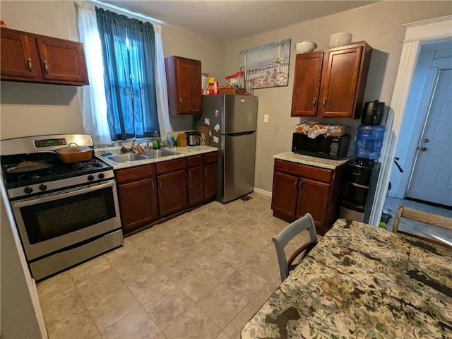 313 Ellicott St, Rochester, NY 14619 - kitchen with appliances with stainless steel finishes, a sink, and light stone countertops