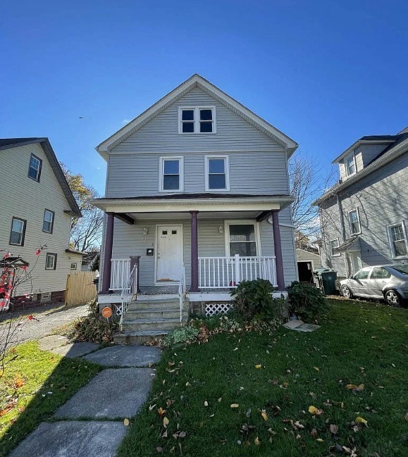 313 Ellicott St, Rochester, NY 14619 - view of front of house featuring covered porch and a front lawn
