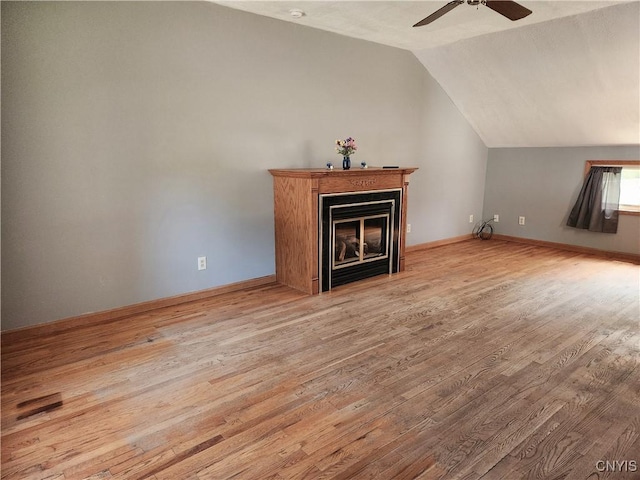 116 Kendall Dr E, Manlius, NY 13057 - unfurnished living room with vaulted ceiling, wood finished floors, a ceiling fan, and a glass covered fireplace