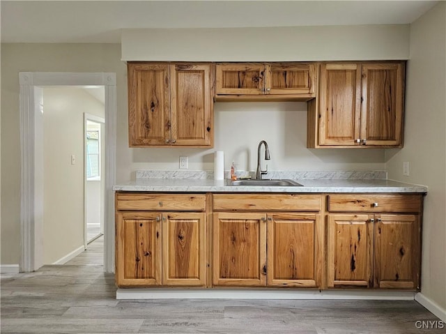 11 Bryant St, Utica, NY 13502 - kitchen featuring a sink, brown cabinetry, and light wood finished floors
