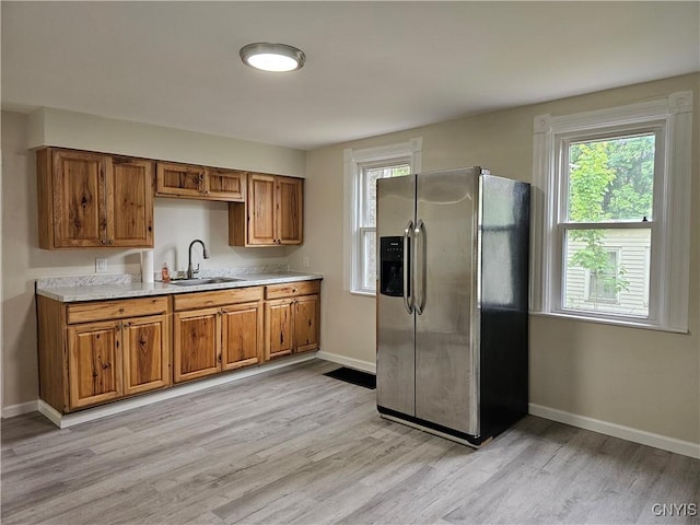 11 Bryant St, Utica, NY 13502 - kitchen featuring stainless steel fridge with ice dispenser, a sink, brown cabinets, light countertops, and baseboards