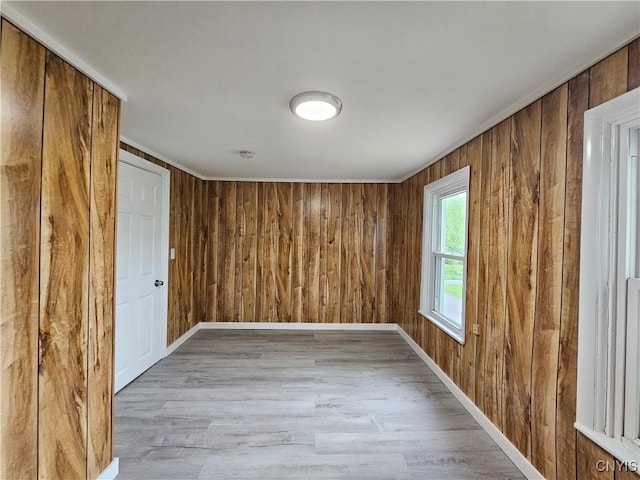 11 Bryant St, Utica, NY 13502 - unfurnished room with light wood-type flooring, wood walls, baseboards, and a smoke detector